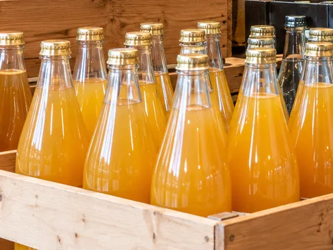 Flaschen mit naturtrübem Apfelsaft in der Holzkiste