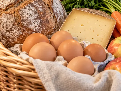Braune Eier im Weidenkorb mit Leinentuch